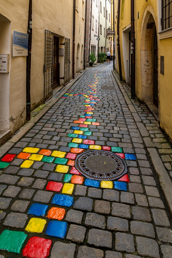 Passau's narrow Artists Alley with stones painted bright, rainbow colors.