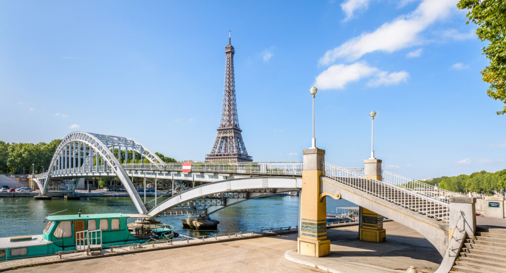 One of the interesting bridges in Paris with steel arches, and Eiffel Tower in background.
