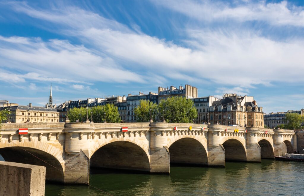 Ornate Paris  bridge with water below and buildings background. 