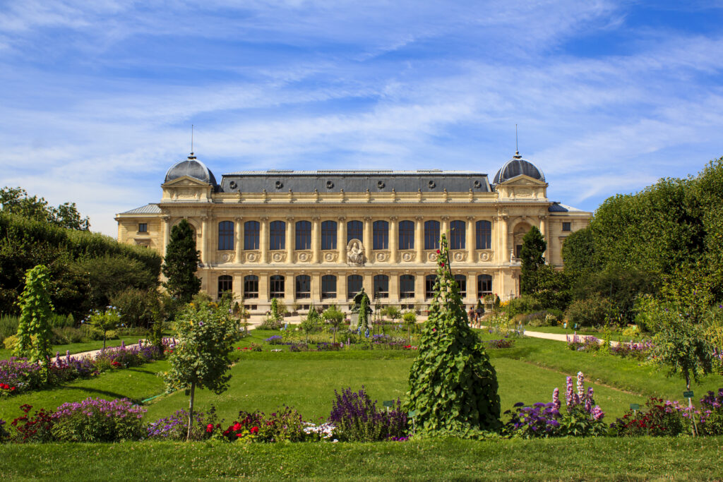 Large ornate building with colorful garden in foreground