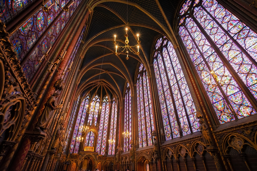 Looking up at stunning, purple stained glass windows and hanging chandeliers in Saint-Chapelle.