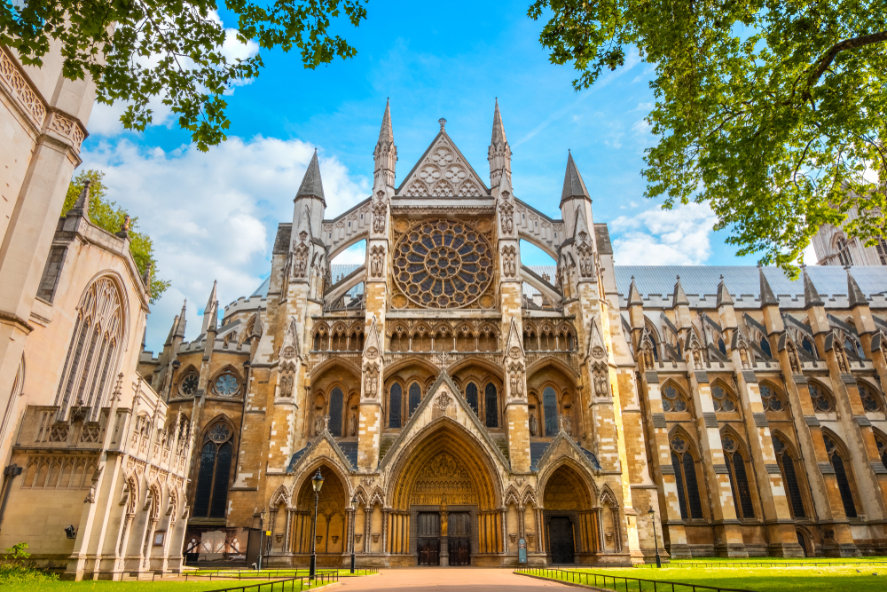 The entrance to the Gothic Westminster Abbey with a rose window and intricate details seen on a London-Paris itinerary.