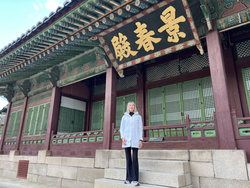 Woman standing in front of a tradition Korean building.