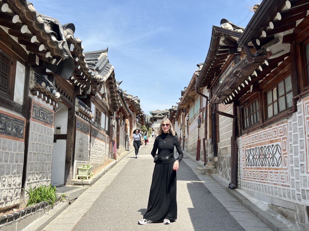 Woman standing on  street among traditional buildings.