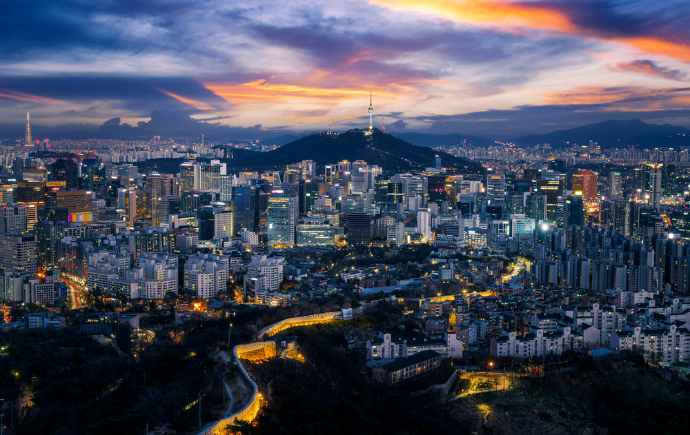 Vivid sunset over the sprawling, lit-up skyline of Seoul, South Korea.