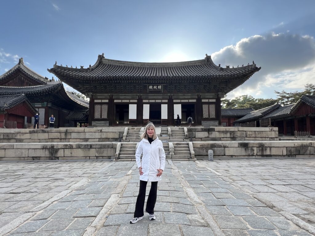Woman standing in front of beautiful, traditional Korean buildings.