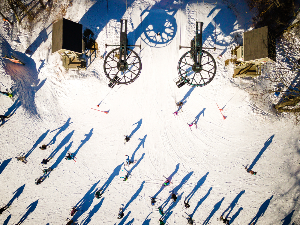 aerial view of snow covered mountain with people skiing on top poconos in the winter