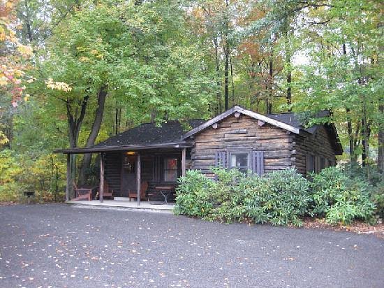 Log Cabin in the woods with trees behind. One of the resorts in Poconos