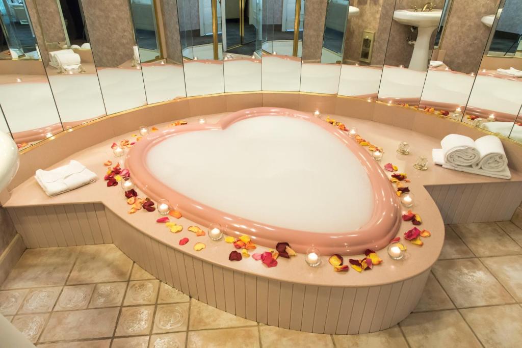A pink love heart bath full of bubbles and surrounded by flowers in an article about resorts in Poconos 