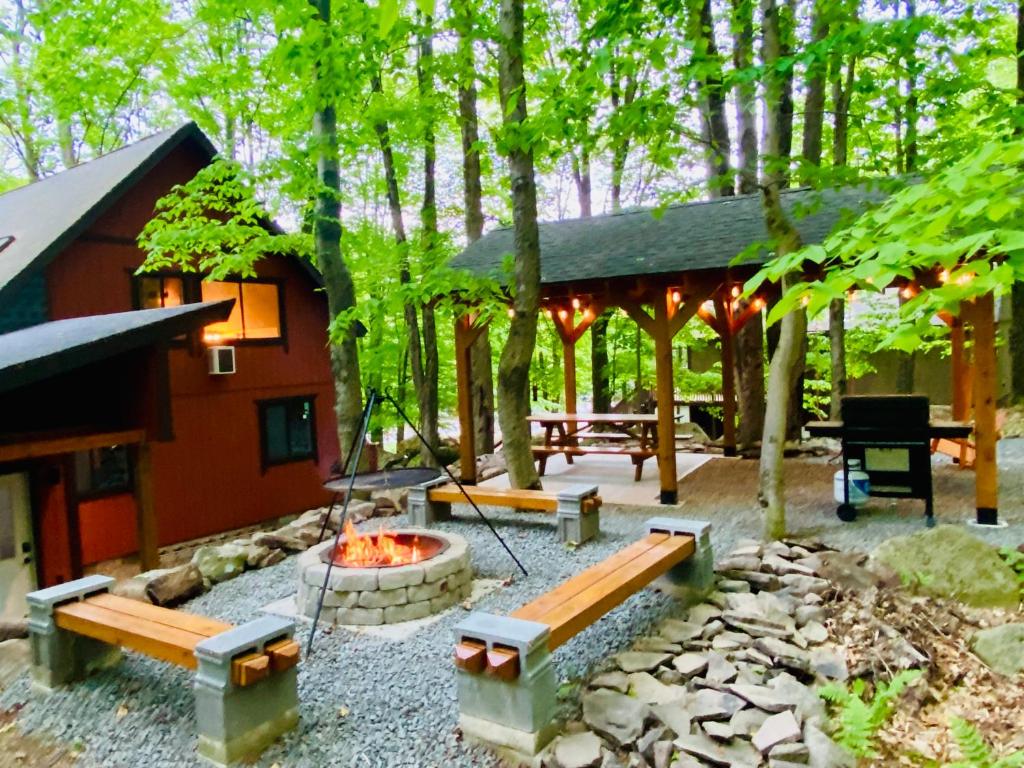 Log Cabin in the woods with a fire pit and seating area outside. Perfect for romantic getaways in the Poconos.