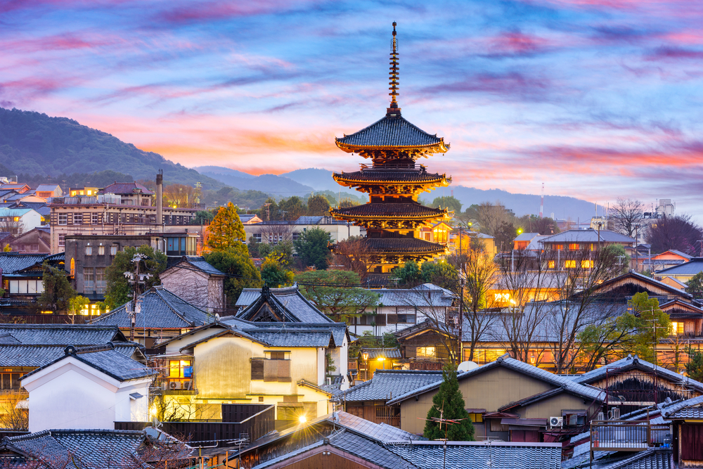 japanese buildings in a district with mountains in the background in the evening best things to do in kyoto