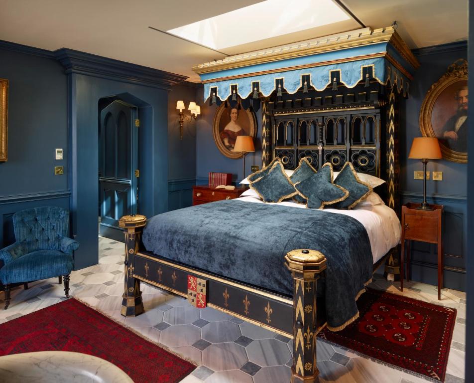 luxury bed with blue velvet cover in a very opulent room.  One of the romantic things to do in London