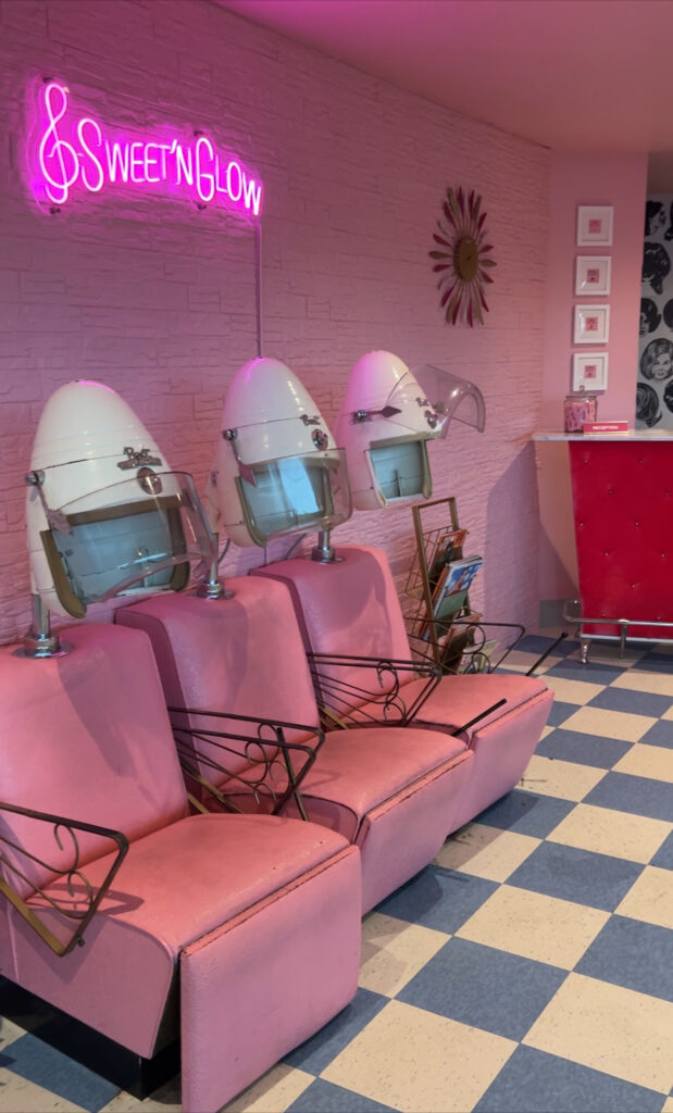 The old fashioned hair salon with a pink wall and chairs. 