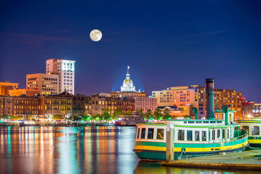 boat on the dock with city in the background and a full moon in the sky christmas in savannah