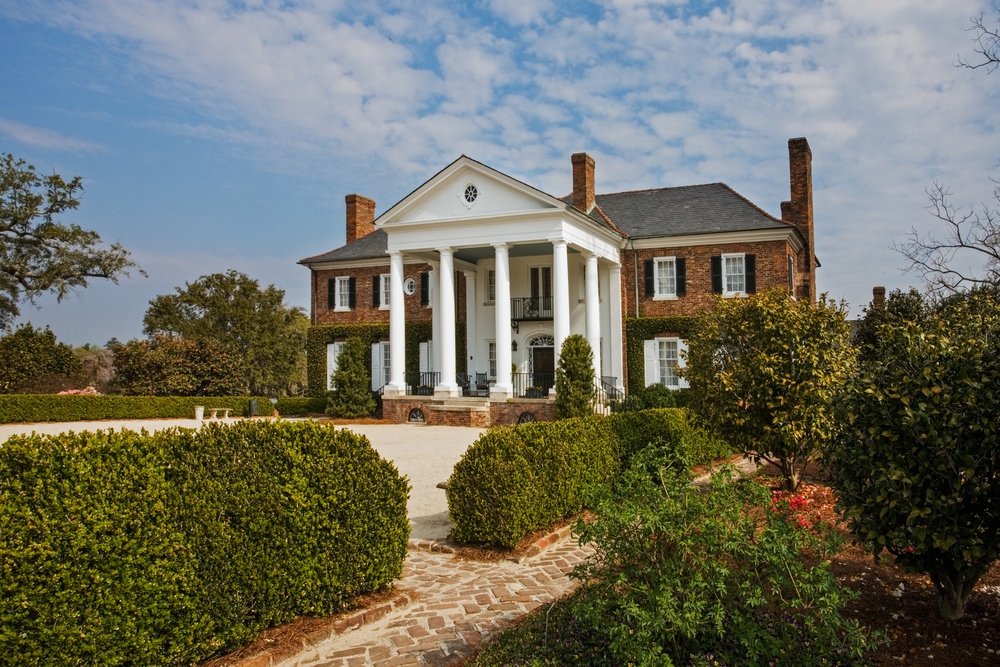 plantation house surrounded by trees and bushes