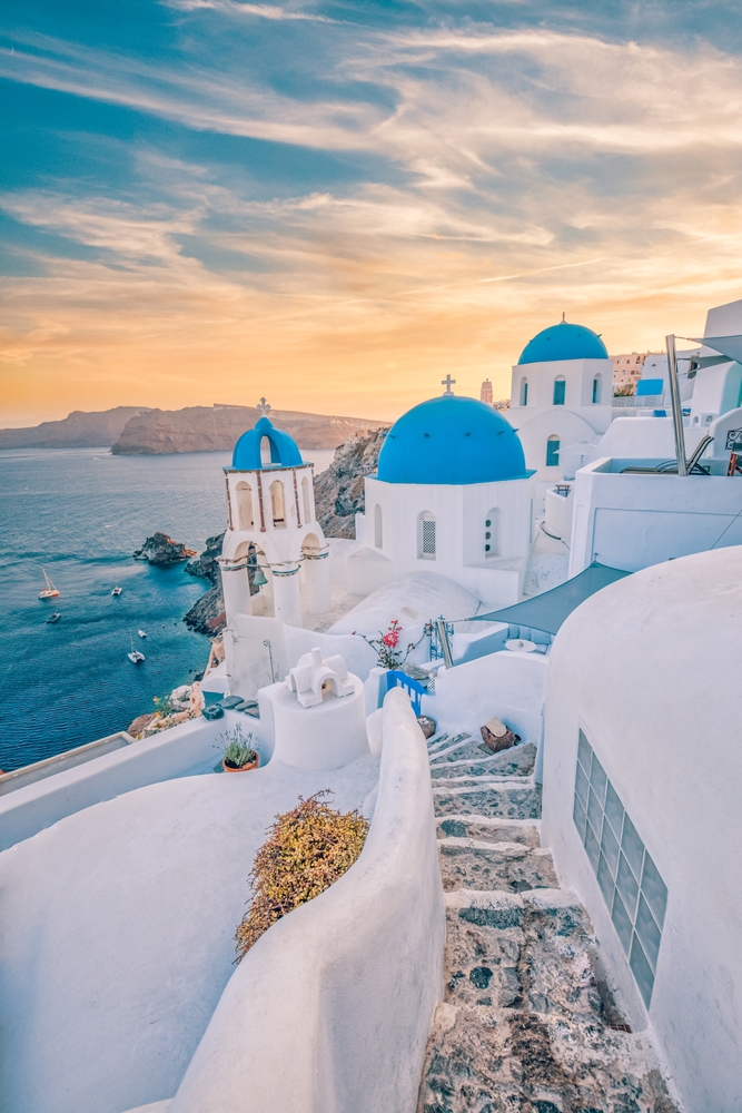 Santorini island, Greece. Amazing romantic sunrise in Oia background, morning light. Amazing sunset view with white houses blue domes. Panoramic travel landscape