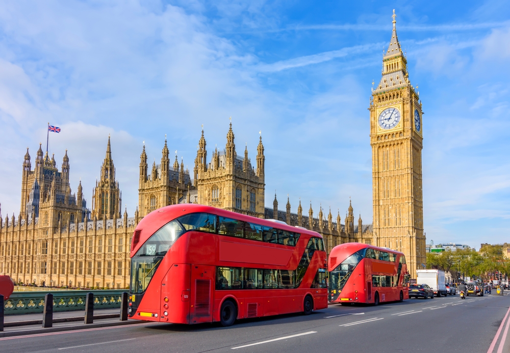 Houses of Parliament with Big Ben and double-decker buses on Westminster bridge, London