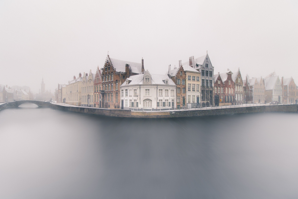 foggy winter view of Spinolarei & Spiegelrei canal in Bruges. One of the places to visit in Europe in winter