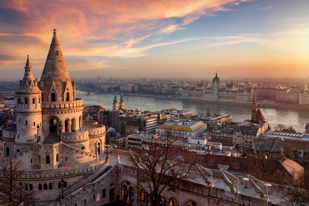 The Fisherman's Bastion from above with Hungarian Parliament building and River Danube during a golden sunrise in Budapest. One of the places to go in Europe in winter. 