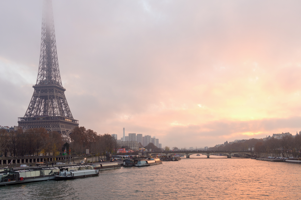 landscape with eiffel tower, fog and Seine river in Paris, France at sunset.