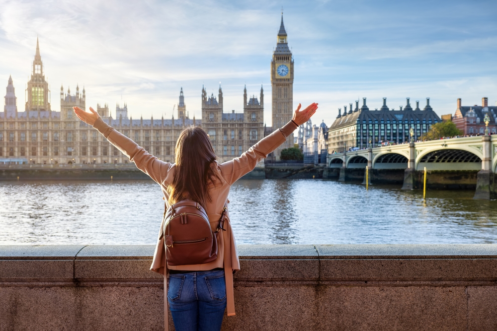 girl with daypack and arms open in europe