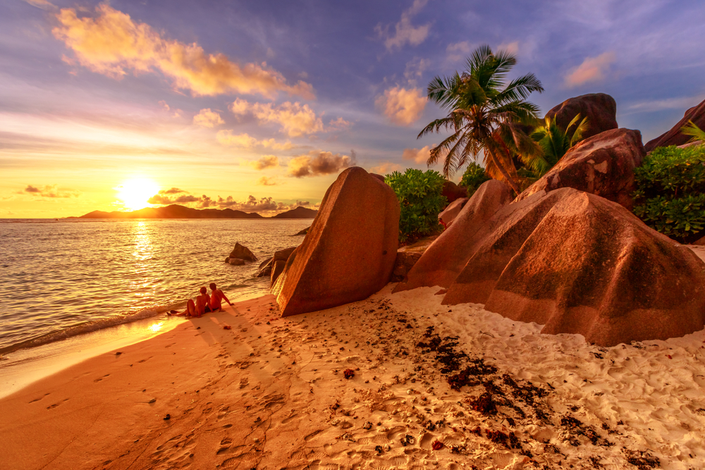 shoreline near shaped granite stones of Anse Source d'Argent with sunset sky. Seychelles one of the best beaches in the world. 