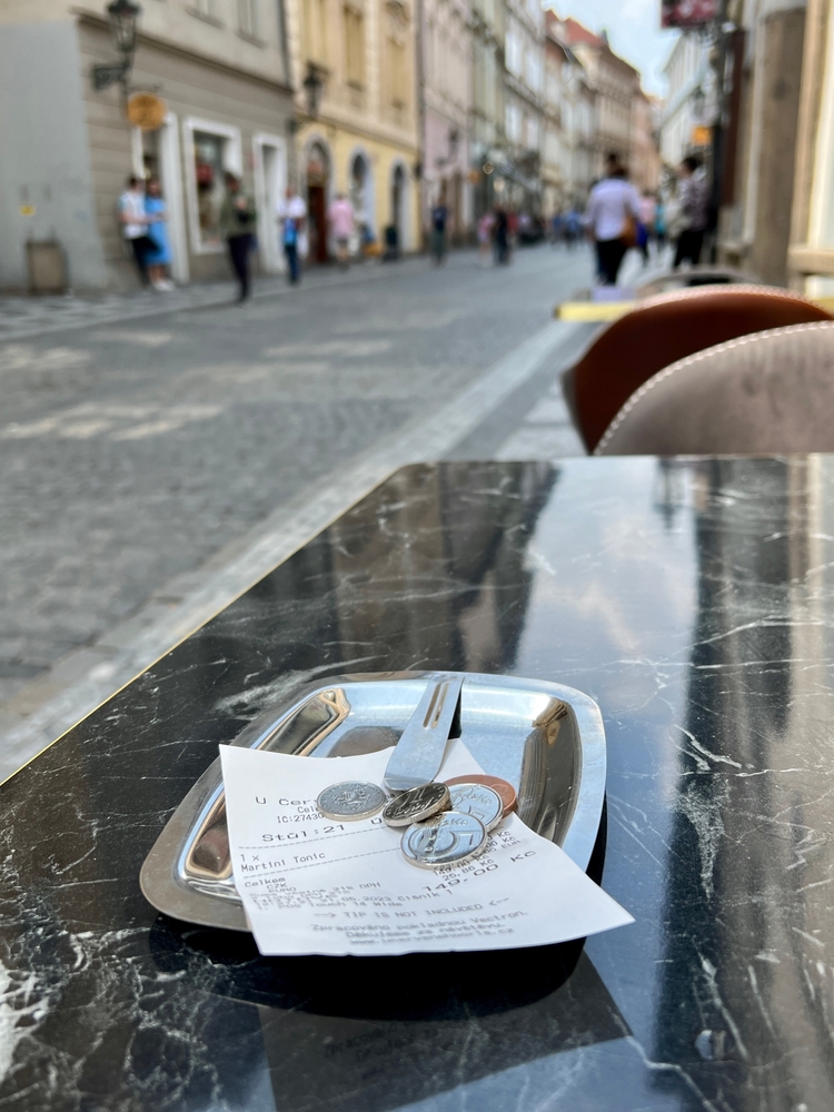 Money left as a tip on a table. The article is about traveling to Europe. 