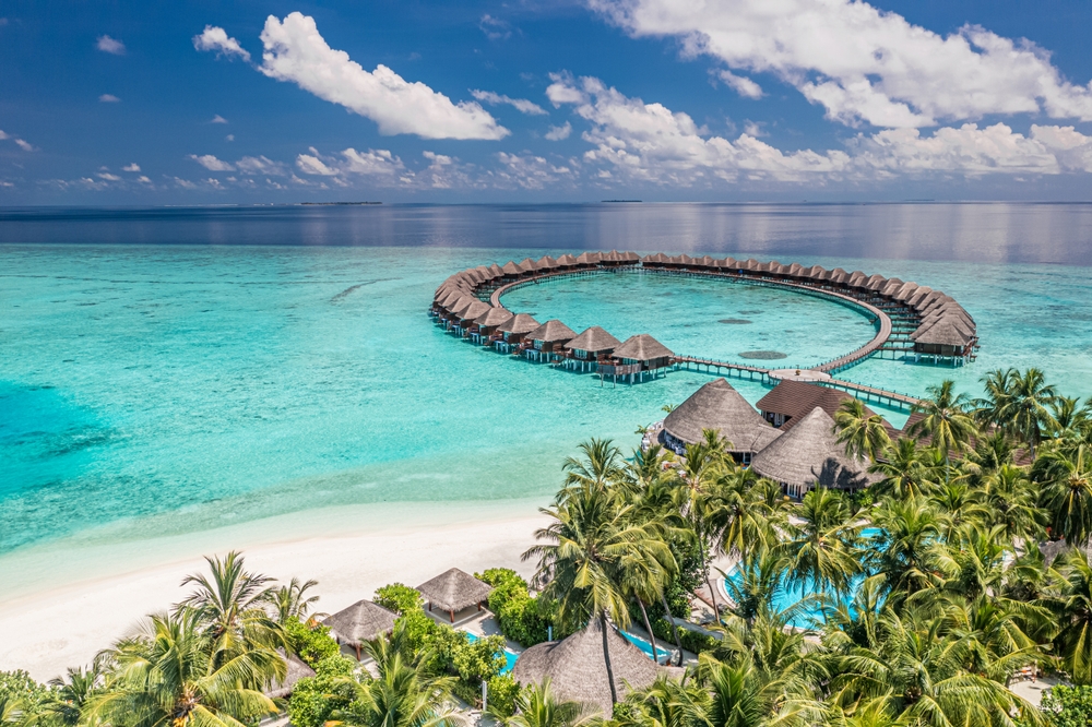 Aerial image of overwater bungalows on the clear ocean in the Maldives.