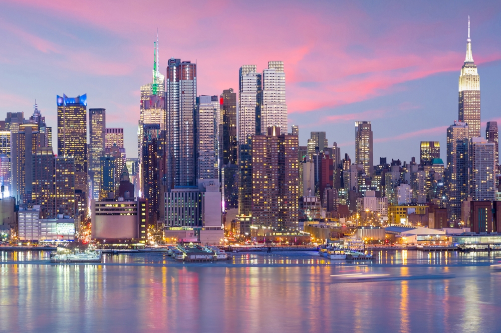 Pink sunset over the New York City skyline and the river.