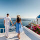 A couple holding hands overlooking the ocean in Santorini, Greece, one of the best honeymoon destinations in the world.