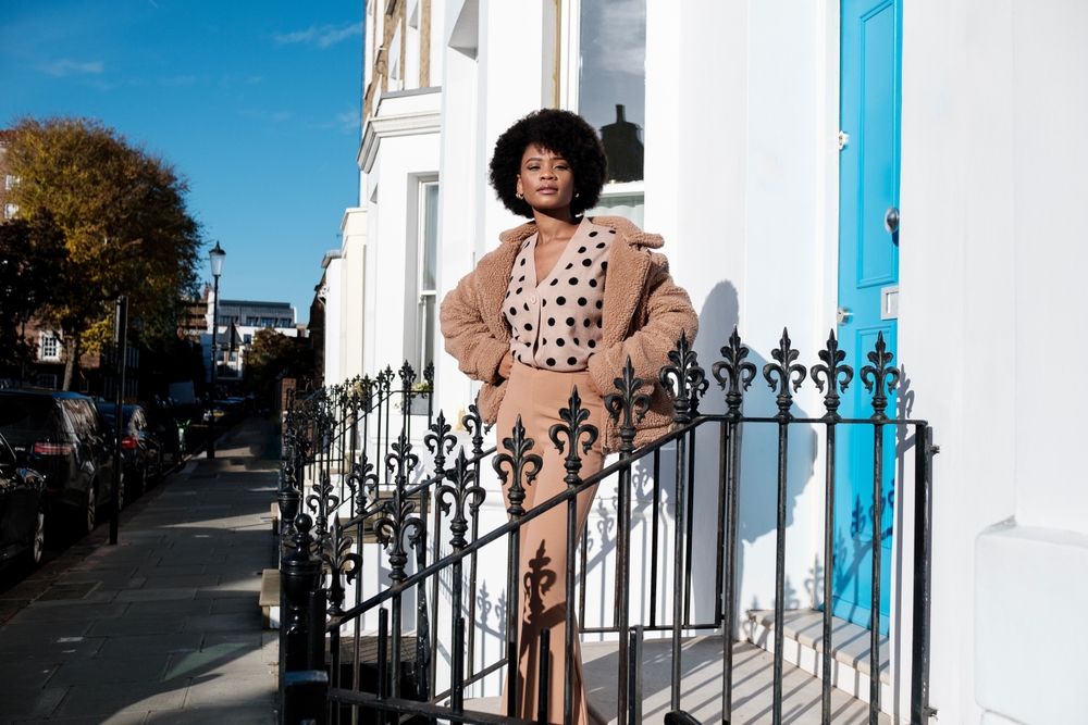 Girl stood on steps in London wearing a wonderful outfit.  