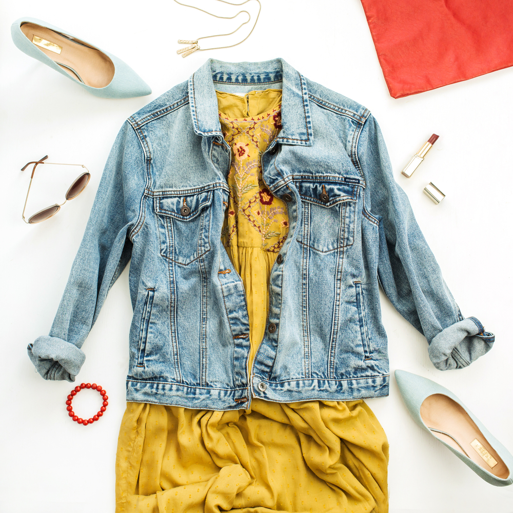 A flay lay of London outfits for summer. There is a dress and a denim jacket. 