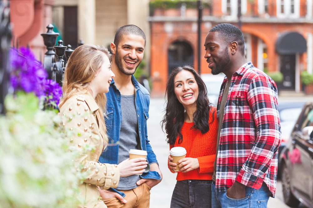 Group of friends talking on the street in London in Spring. 