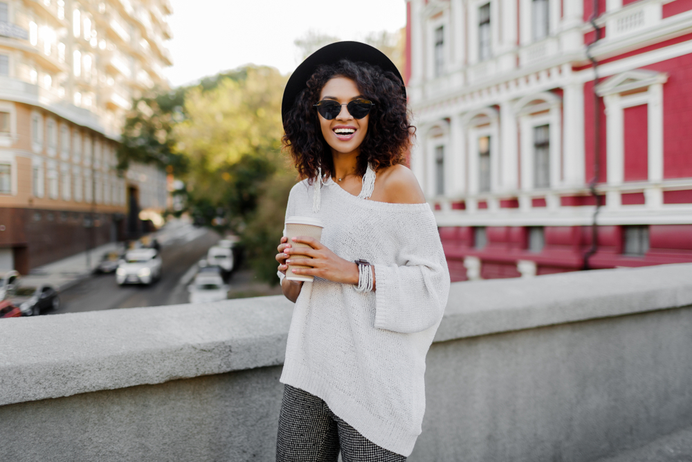 Girl in hat and casual top in London in spring. Article is about  what to wear in London in spring. 