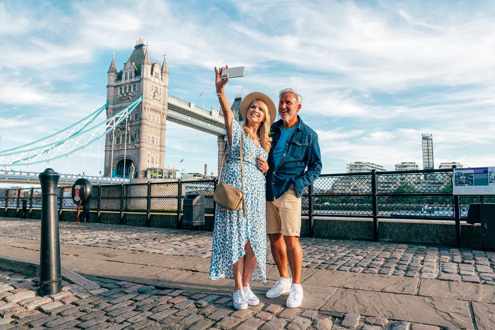 Women in blue dress and sneakers with a man taking a picture in London