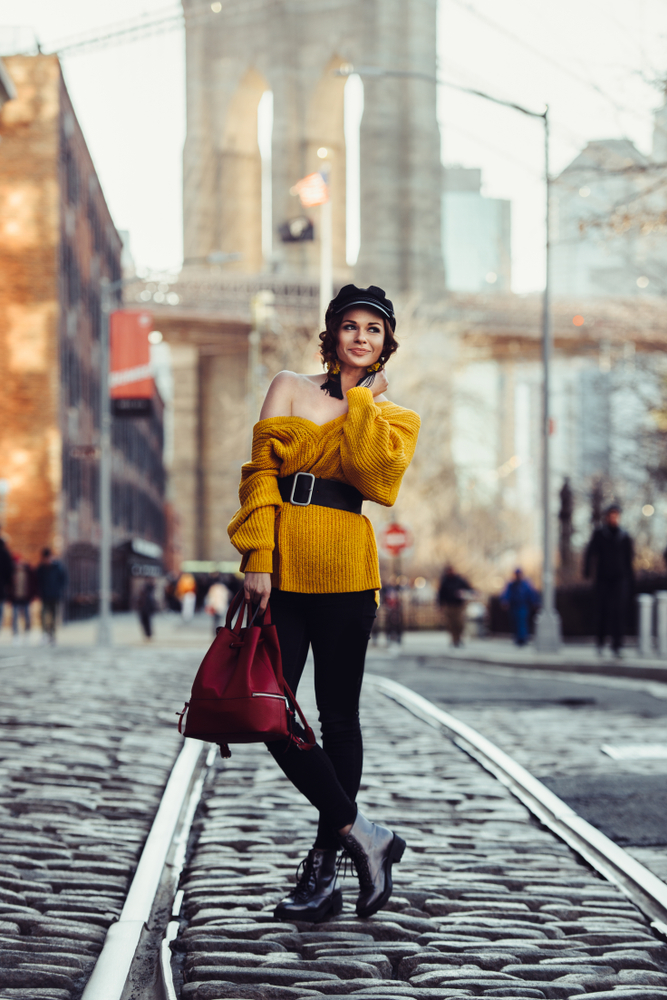 Beautiful happy young fashionable woman traveling in New York City with backpack. 