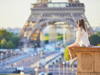 women in shirt and shorts sitting and watching eiffel tower what to wear in paris in summer