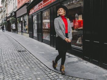 woman wearing red top with black skirt and thermal leggings on a street paris in winter