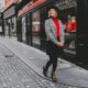 woman wearing red top with black skirt and thermal leggings on a street paris in winter