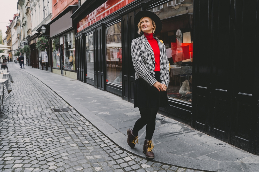 woman wearing red top with black skirt and thermal leggings on a street paris in winter