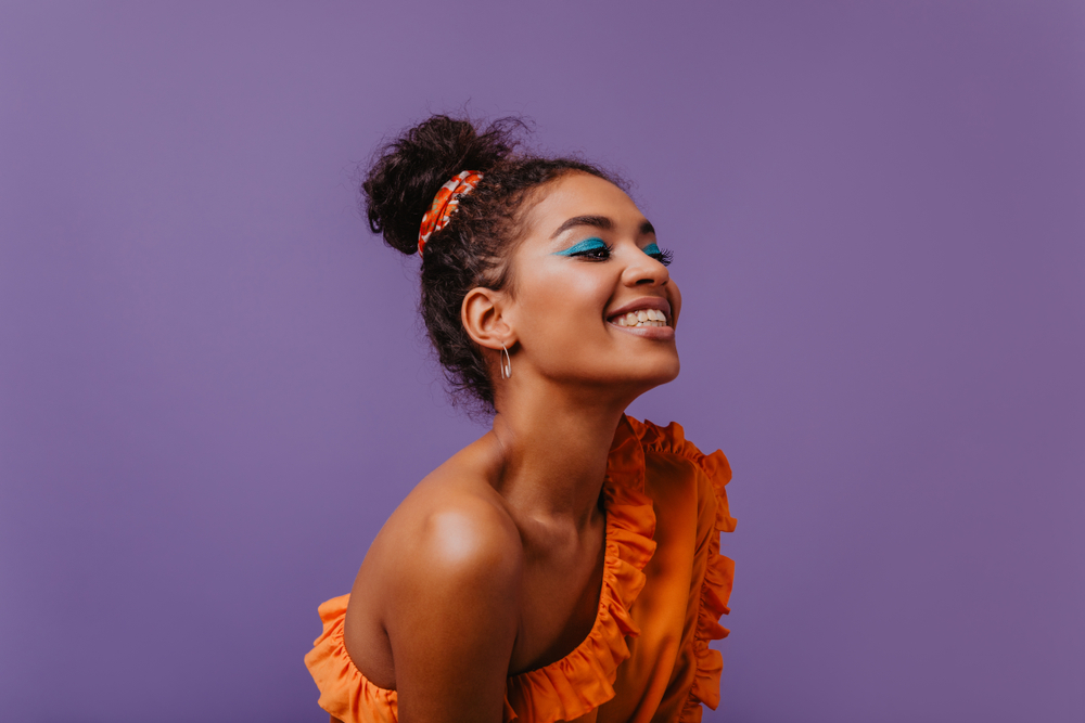  Black woman in summer dress laughing on violet background. what to wear in NYC in summer 