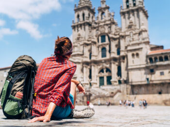 woman backpacker sitting outside a religious site traveling to spain