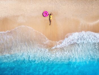 aerial view of a girl lying on the beach traveling to the maldives