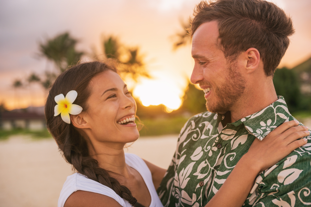 Smiling couple hugging at sunset.