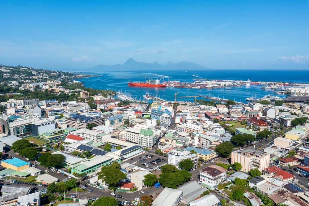Aerial view of the town of Papeete with the ocean in the distance.