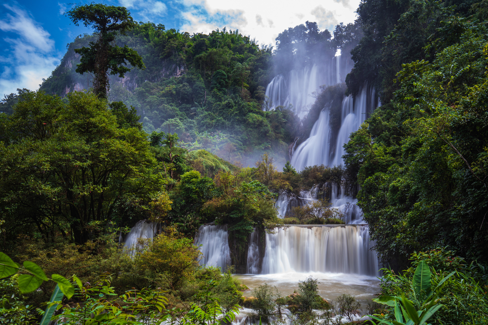 The beautiful, tiered Thi-Lo-Su waterfall cascading down among lush foliage in a jungle in Thailand.