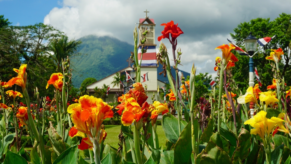 Beautiful view from the park in La Fortuna on the central church and the Arenal volcano in the background.