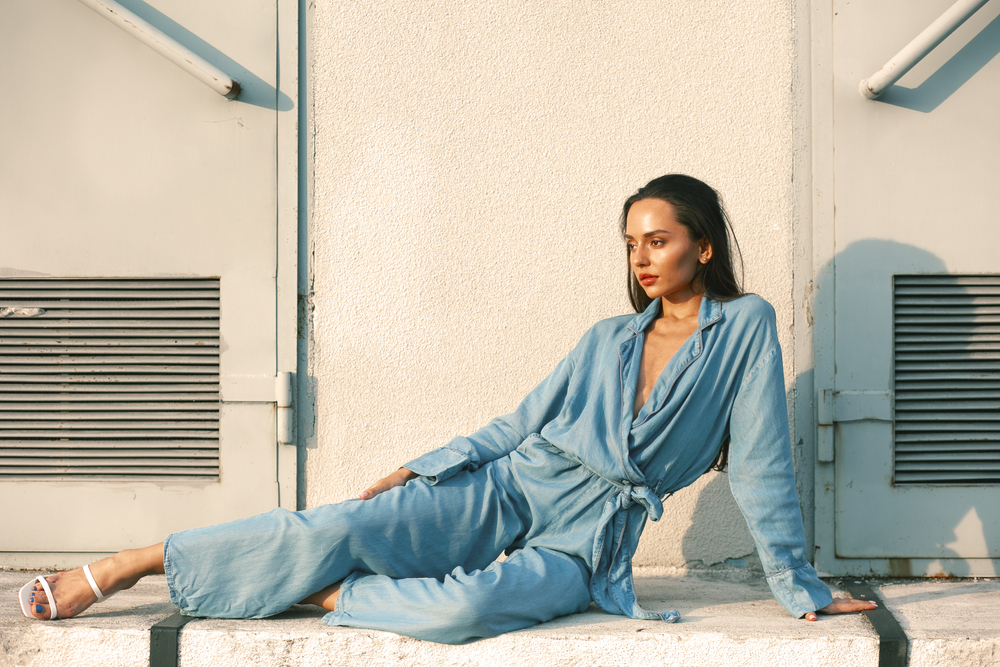 Girl say on group in a blue jumpsuit.