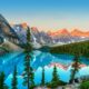 sunrise light on the mountains surrounding clear blue lake with trees around things to do in banff