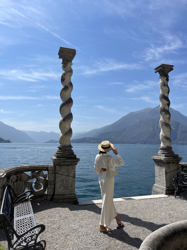 fashion outdoor photo of beautiful woman with dark hair in elegant clothes posing in luxurious villa at Como lake in Italy